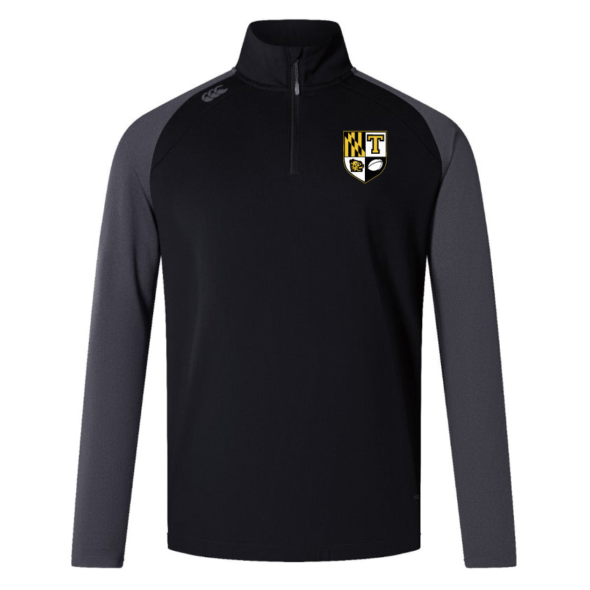 The Towson University Rugby Women's Elite First Layer by EMB Canterbury is a black and gray long-sleeve quarter-zip pullover made from honeycomb fabric, featuring a logo with a shield, "T," and checkered pattern. VapoDri technology enhances comfort.