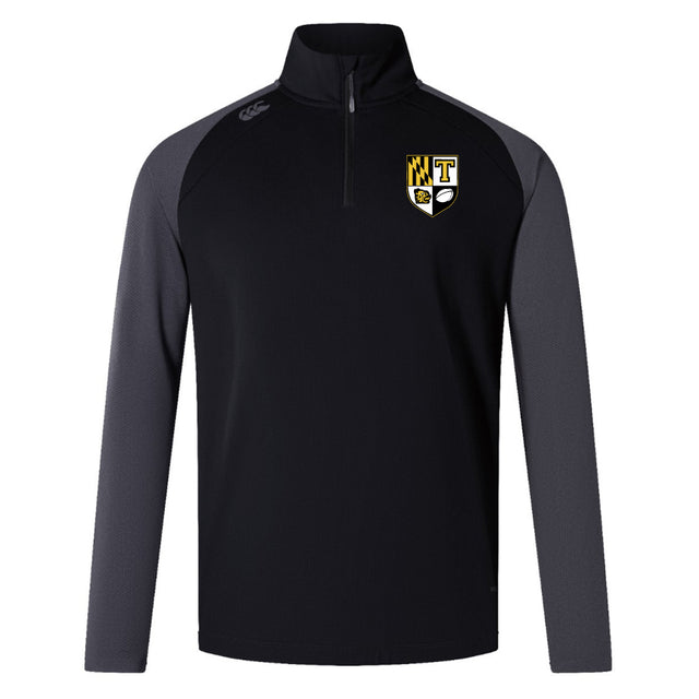 The Towson University Rugby Women's Elite First Layer by EMB Canterbury is a black and gray long-sleeve quarter-zip pullover made from honeycomb fabric, featuring a logo with a shield, "T," and checkered pattern. VapoDri technology enhances comfort.