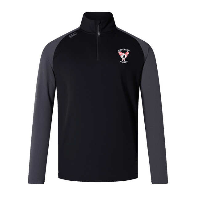 The EMB Canterbury Superior Rugby Club Elite First Layer features a black body, dark gray sleeves, and a Superior Rugby logo on the left chest, crafted in the signature Canterbury style.