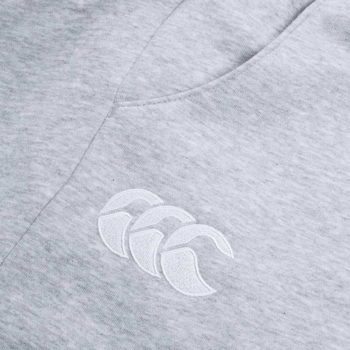 The Women's Leisure Sweatpant by Canterbury features a gray cotton blend fleece fabric with a white embroidered Canterbury logo showcasing three overlapping crescent shapes, ideal for casual wear.