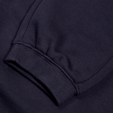 Close-up of a sleeve from Canterbury's Women's Leisure Sweatpant, featuring ribbed cuff detail in a navy blue, cotton blend fleece.