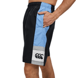 Man wearing Canterbury Legends Panel Short in black and blue with a logo on the right leg, standing against a white background.