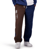 Person wearing Canterbury Harlequin Block Stadium Trackpant in blue and brown with white sneakers, proudly displaying the CCC logo on the left leg.