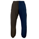 The Canterbury Harlequin Block Stadium Trackpant features color-blocked pants with an elastic waistband; the left pant leg is dark brown, and the right pant leg is navy blue. Adorned with the CCC logo, these versatile track pants from Canterbury are a stylish addition to any activewear collection.