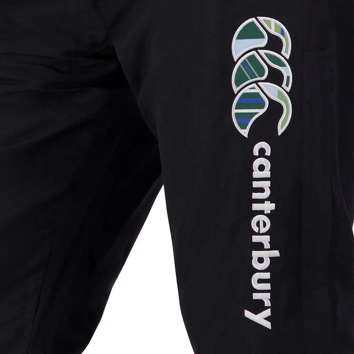 Close-up of Canterbury Uglies Stadium Pants showcasing the brand's logo and text embroidered in white and green on the side, featuring a stylishly tapered leg.