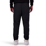 A person standing, viewed from the back, wearing black Canterbury Uglies Stadium Pants by Canterbury with a tapered leg, paired with a black top and white shoes.