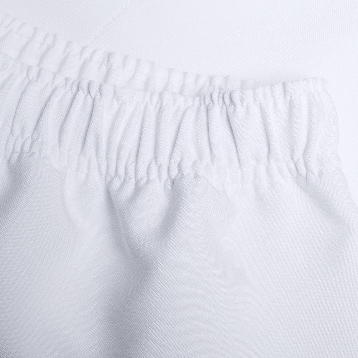 Close-up of a white fabric with an elastic band, likely part of the Canterbury Player's Drill Short, showing detail in the stitching and texture.