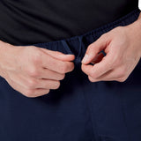 A person tightens the drawstring on a pair of Canterbury Player's Drill Shorts in navy blue.