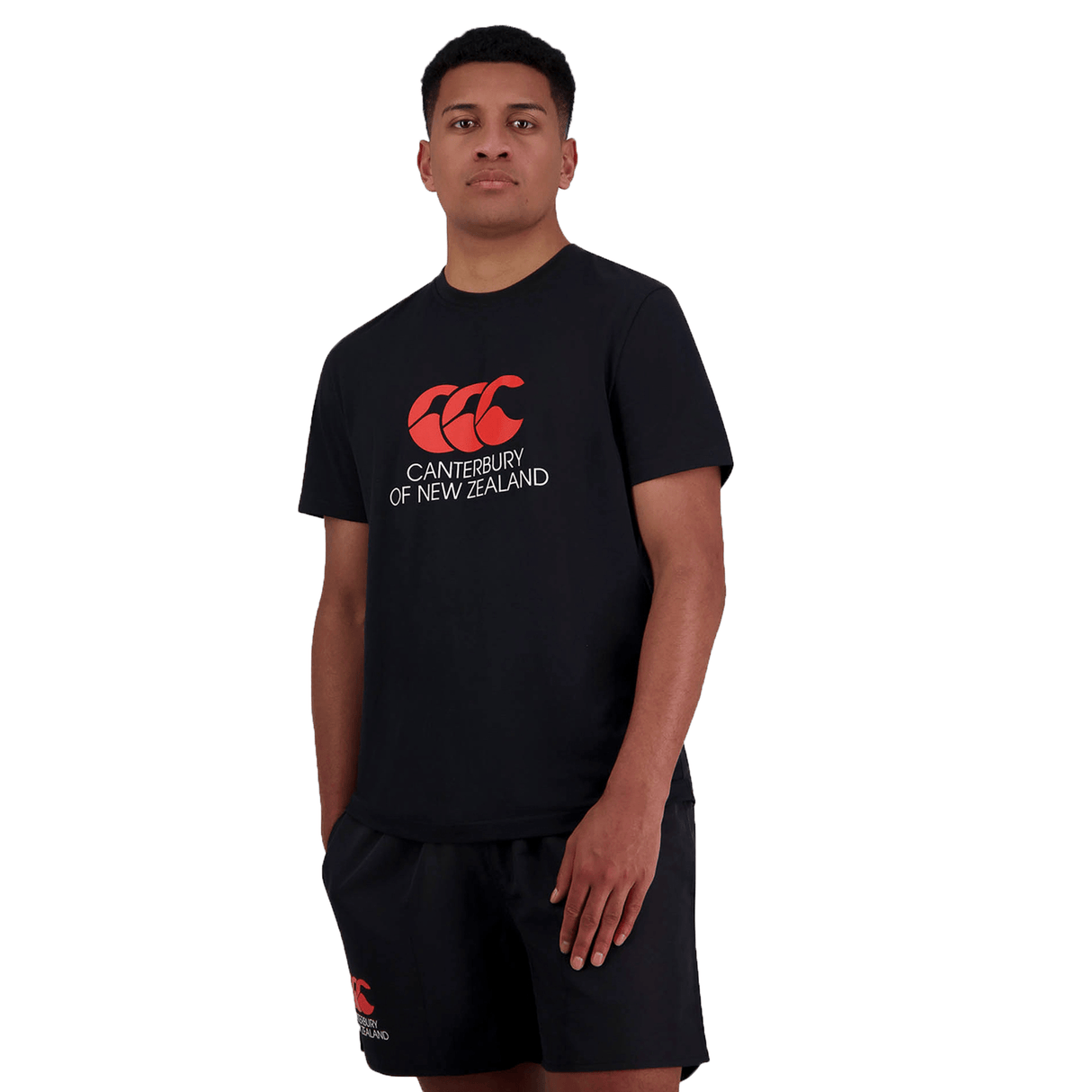 A person is standing, wearing black athletic clothing with the text "Canterbury of New Zealand" on the Canterbury of New Zealand Logo T-Shirt by Canterbury.