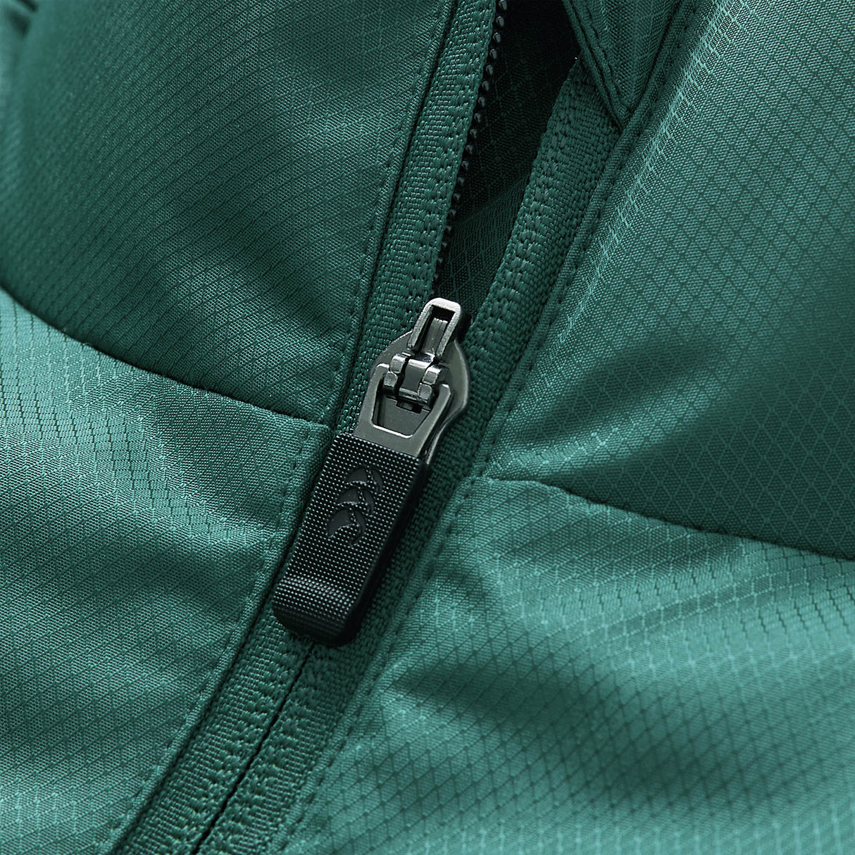Close-up of the Ireland 26 Puffer Jacket by Canterbury, featuring green quilted fabric and a partially zipped metal zipper with a textured pull.