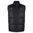 The Ireland 24 Padded Gilet by Canterbury is a sleeveless black puffer vest with Thermoreg insulation, featuring a zip front and adorned with green emblems and logos on the chest.