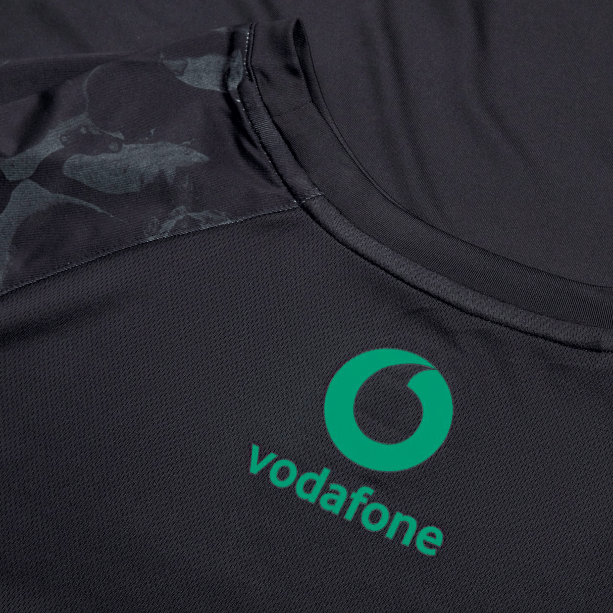 The Ireland 24 Superlight Training T-Shirt by Canterbury is a dark jersey made from recycled polyester, featuring a green Vodafone logo on the chest area.