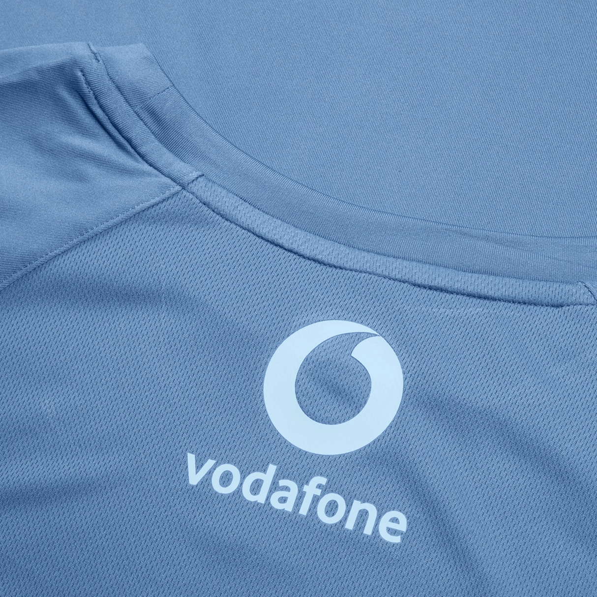 Close-up of the back of a blue Ireland 24 Superlight Training T-Shirt by Canterbury featuring the Vodafone logo in white, often seen on Ireland's athletic wear.