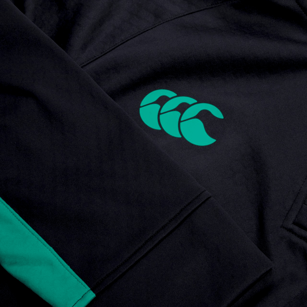 A close-up of the Ireland 1/4 Zip Training Top 24 by Canterbury, featuring a prominent green Canterbury logo and green detailing on the sleeve.