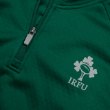 Close-up of the Ireland 1/4 Zip Training Top 24 by Canterbury in green, showcasing the IRFU logo featuring a rugby ball, shamrock, and the initials "IRFU," along with a zipper detail.