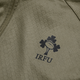 Close-up of the Ireland 25/26 Training Top by Canterbury in khaki, featuring the IRFU logo with three shamrocks and a rugby ball. Built with advanced Thermoreg technology for optimal comfort.