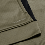 Close-up of olive green fabric with a black accent and "THERMOREG" in white, from the Ireland 25/26 Training Top by Canterbury, featuring a cozy fleece lining.