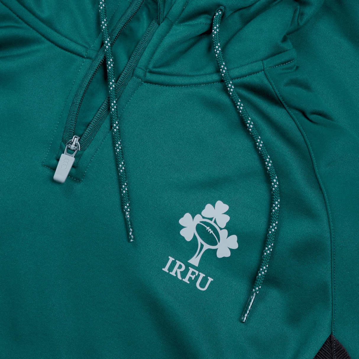 Ireland Training Hoodie 24 by Canterbury, a green sports jacket with a half-zipper, is crafted from 100% Polyester and features the IRFU logo with a rugby ball and three shamrocks. Perfect for an Ireland training session.
