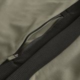 Close-up of the Ireland 25/26 Training Hoodie by Canterbury, featuring a khaki fabric, black ribbed cuff, and open zipper pocket—showcasing signature Canterbury details.