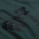 Close-up of the Ireland 26 Elite Training Tee by Canterbury in green, showcasing the IRFU logo with a shamrock and rugby ball motif above the Canterbury brand logo. Crafted from Vapodri breathable sportswear, this elite training shirt is designed to deliver comfort and performance both on and off the field.