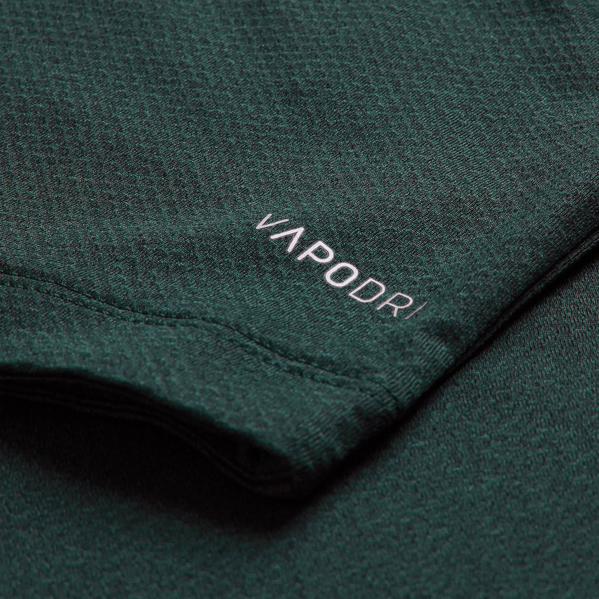 Close-up of a dark green fabric from the Ireland 26 Elite Training Tee by Canterbury, featuring the word “VAPODRI” printed in white near the edge—a signature of Canterbury’s breathable sportswear technology.