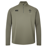 The Ireland 25/26 Elite First Layer 1/4 Zip by Canterbury features long sleeves and IRFU and Canterbury logos on the chest, shown in light olive on a plain white background.