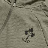 Close-up of the Ireland 25/26 Elite First Layer 1/4 Zip by Canterbury, featuring a textured gray fabric, zipper, and IRFU logo with rugby ball and shamrocks.