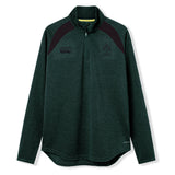 The Ireland 26 Elite First Layer by Canterbury is a dark green, long-sleeve quarter-zip pullover featuring black shoulder accents and chest logos. Crafted from Vapodri fabric for superior moisture management, this top is part of the Canterbury Elite collection and is shown here on a white background.