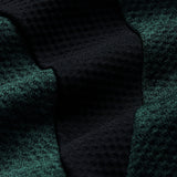 Close-up of textured dark green and black fabric with a waffle-like pattern and visible folds, highlighting the advanced Vapodri technology featured in the Ireland 26 Elite First Layer by Canterbury.