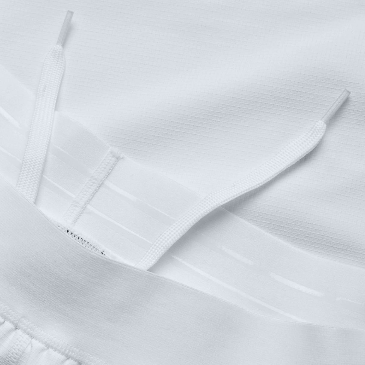 Close-up of a white fabric with drawstrings and ribbed texture, reminiscent of the Ireland 150th Anniversary Home Match Short by Canterbury.