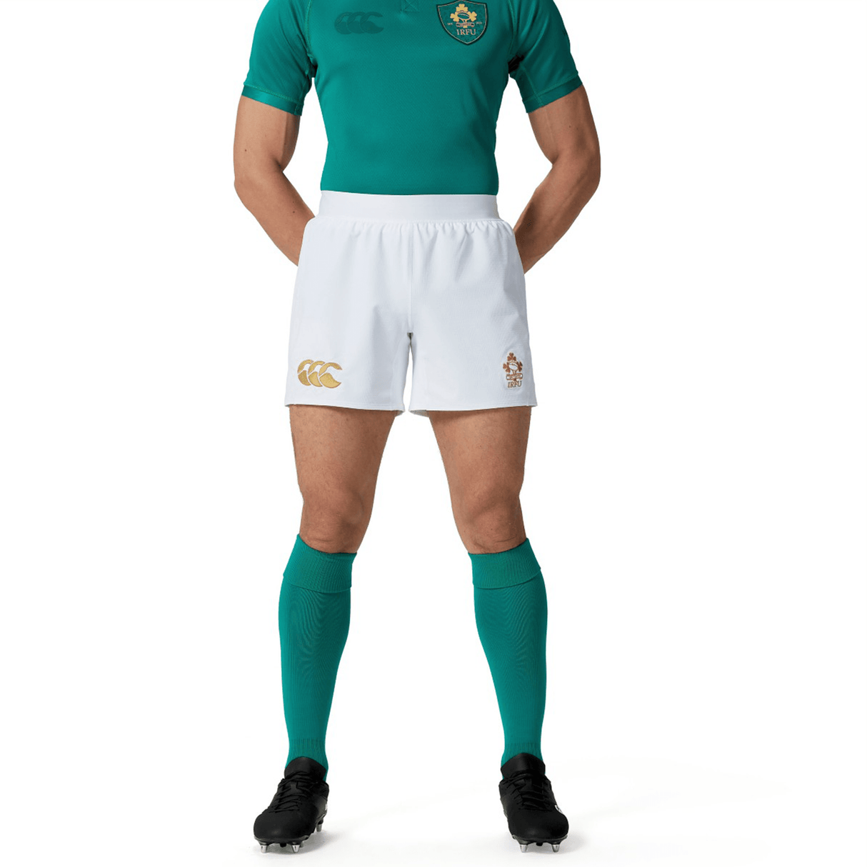 A person dressed in a green sports jersey, Ireland 150th Anniversary Home Match Shorts by Canterbury, and green knee-high socks is posing with hands behind their back, celebrating Ireland's 150th Anniversary with pride.