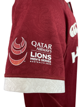 Close-up of a red British & Irish Lions 2025 Players Authentic Jersey by Canterbury. It features "Qatar Airways" and "Lions Men's Series Australia 2025," with a logo on the sleeve and a grandad collar adding classic style.