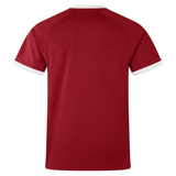 The back view of a plain red short-sleeve t-shirt closely resembles the British & Irish Lions 2025 Players Jersey by Canterbury, highlighted by its white cuffs against an immaculate white backdrop. It is crafted with moisture-wicking fabric to ensure comfort and dryness.