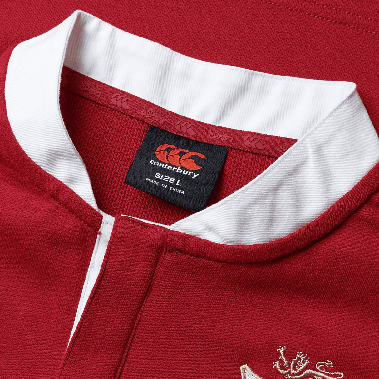 Close-up of the British & Irish Lions 2025 Classic Jersey by Canterbury, showcasing a red design with a nod to traditional styles, complete with a white collar and a label indicating "Size L" and "Made in China.
