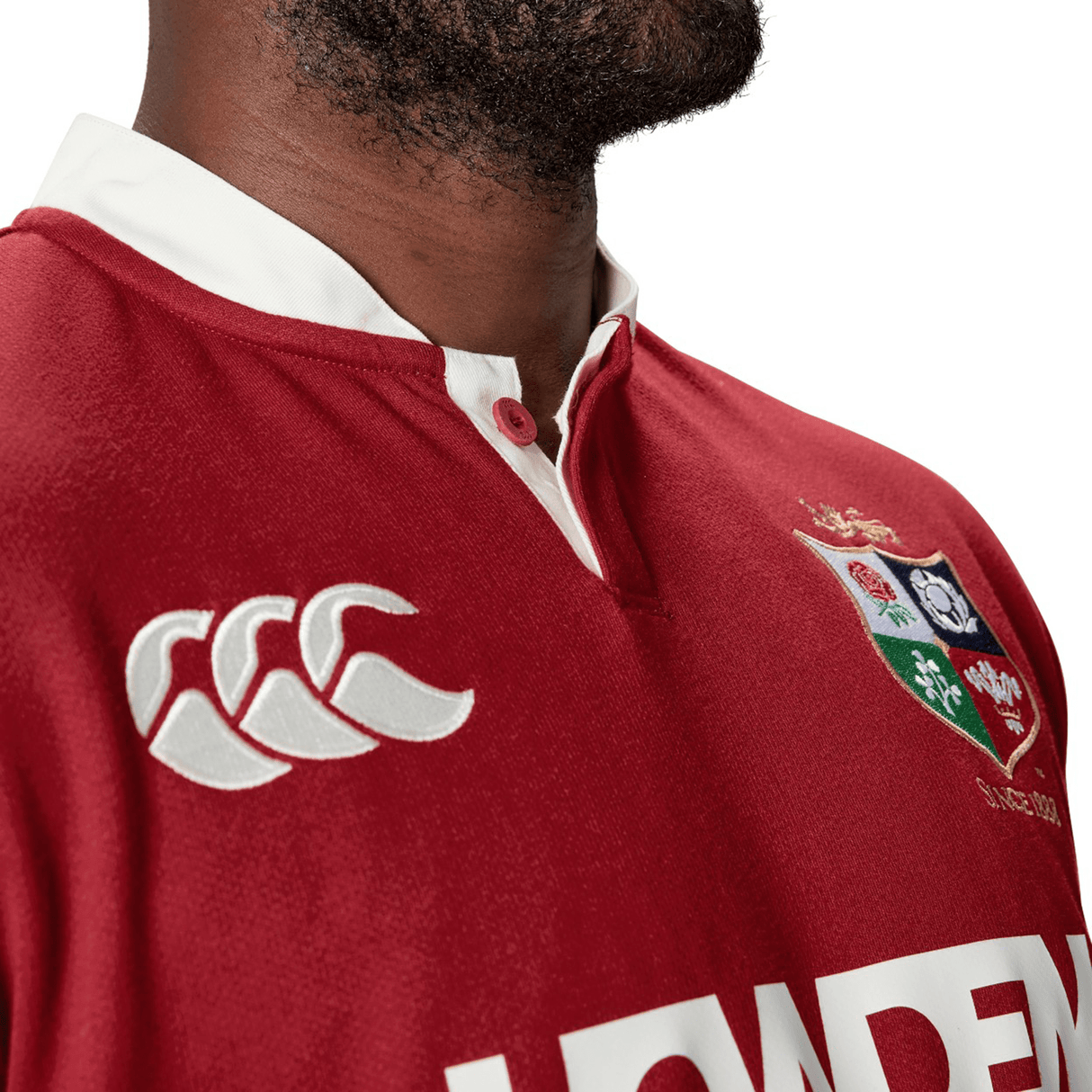 A man wearing the British & Irish Lions 2025 Classic Jersey by Canterbury, showcasing a traditional rugby style with white logos and a classic collar.