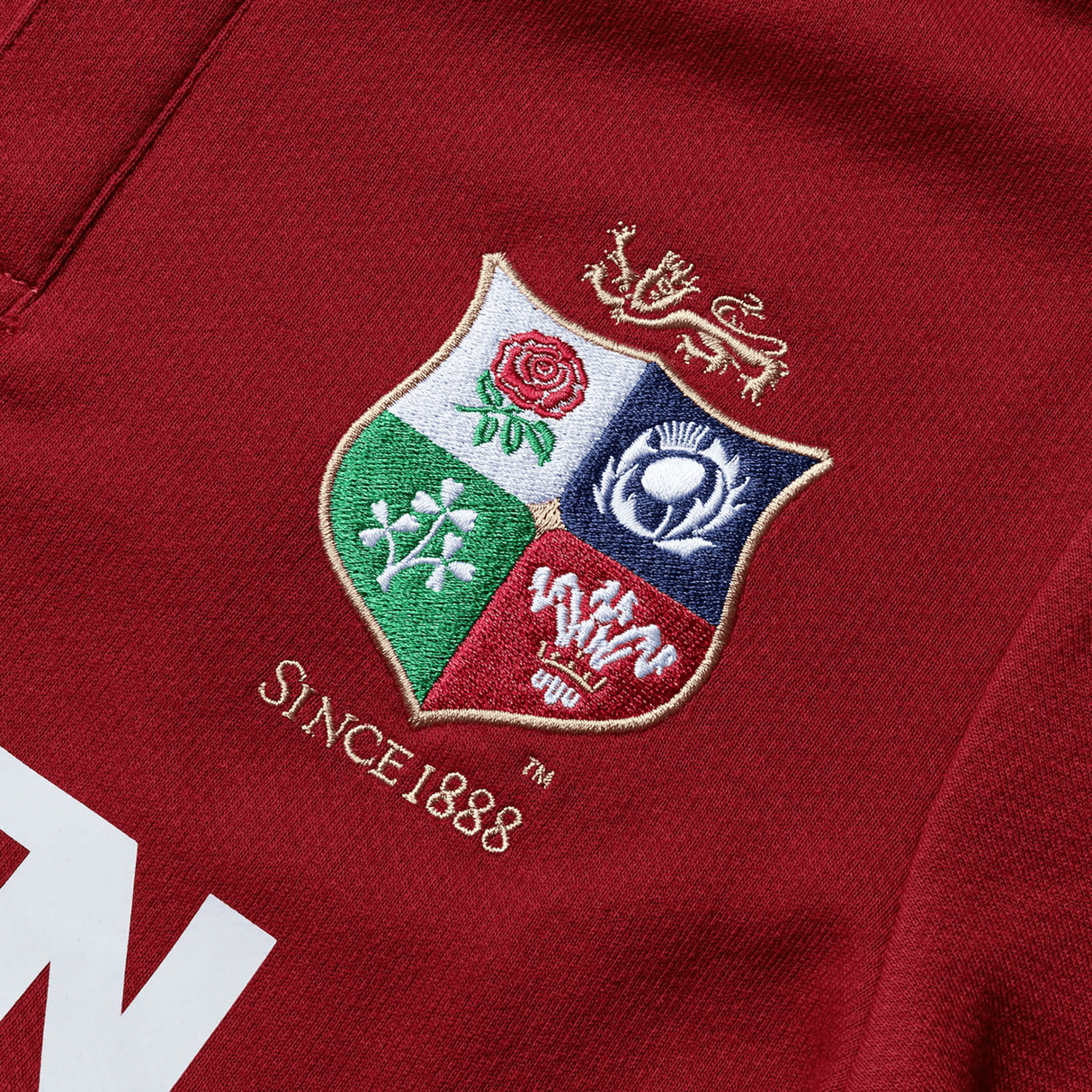 The British & Irish Lions 2025 Classic Jersey by Canterbury showcases a relaxed fit and vibrant red fabric. It features an embroidered coat of arms with four symbolic quadrants, paying homage to the British & Irish Lions heritage, along with the text "Since 1888" underneath.