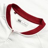 Here is a close-up of the British & Irish Lions 2025 Training Jersey by Canterbury, featuring a striking red collar against its white fabric. The jersey is labeled as size L and boasts recycled content, with ergonomically placed panels designed for enhanced comfort and performance.