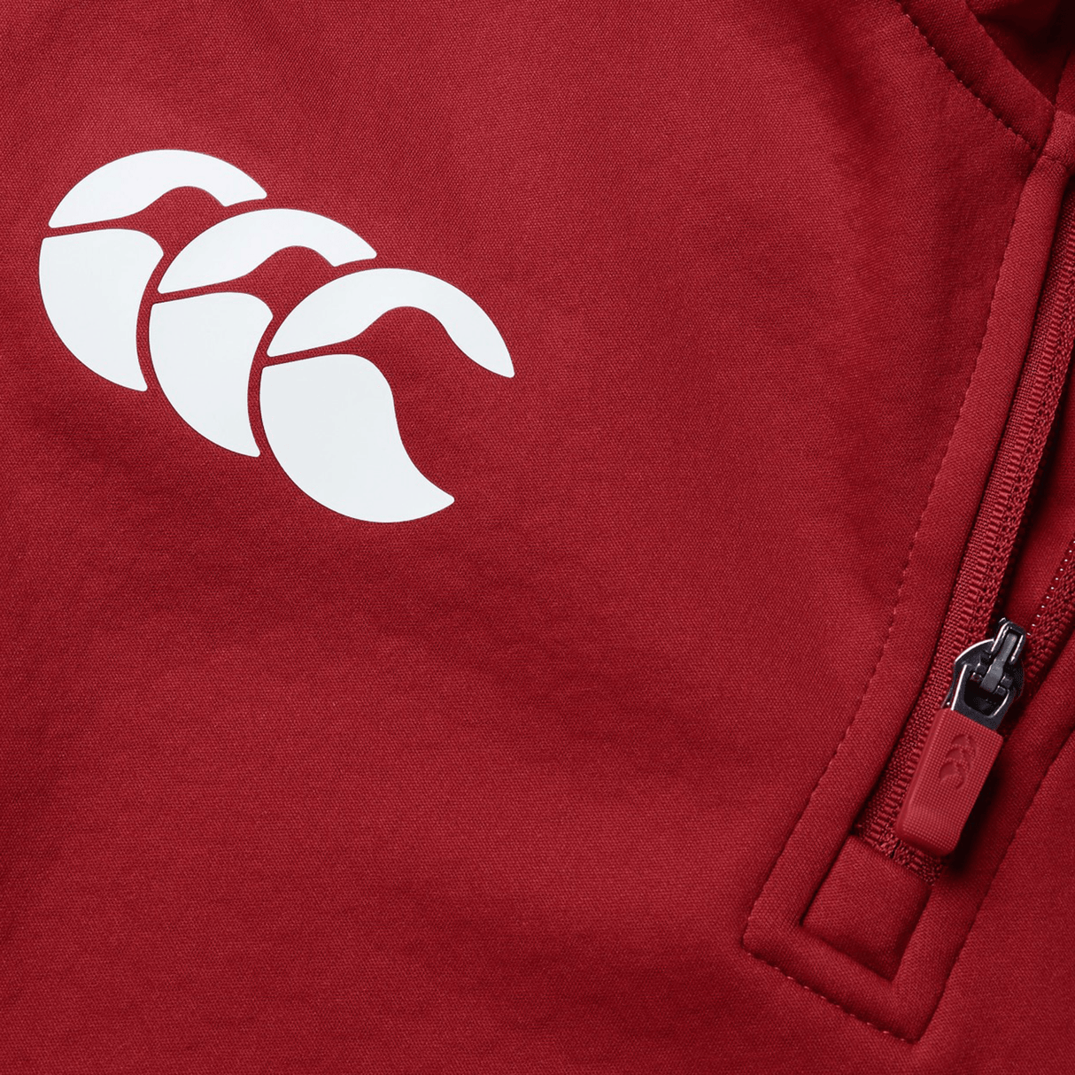 Close-up of the British & Irish Lions 2025 1/4 Zip Fleece by Canterbury in red, featuring a white triple crescent logo and a zippered pocket on the right side.