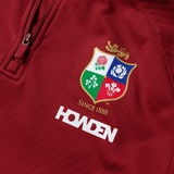 The British & Irish Lions 2025 quarter-zip fleece by Canterbury is a red top showcasing the team's crest with "Since 1888" and "Howden" gracefully printed beneath the logo.