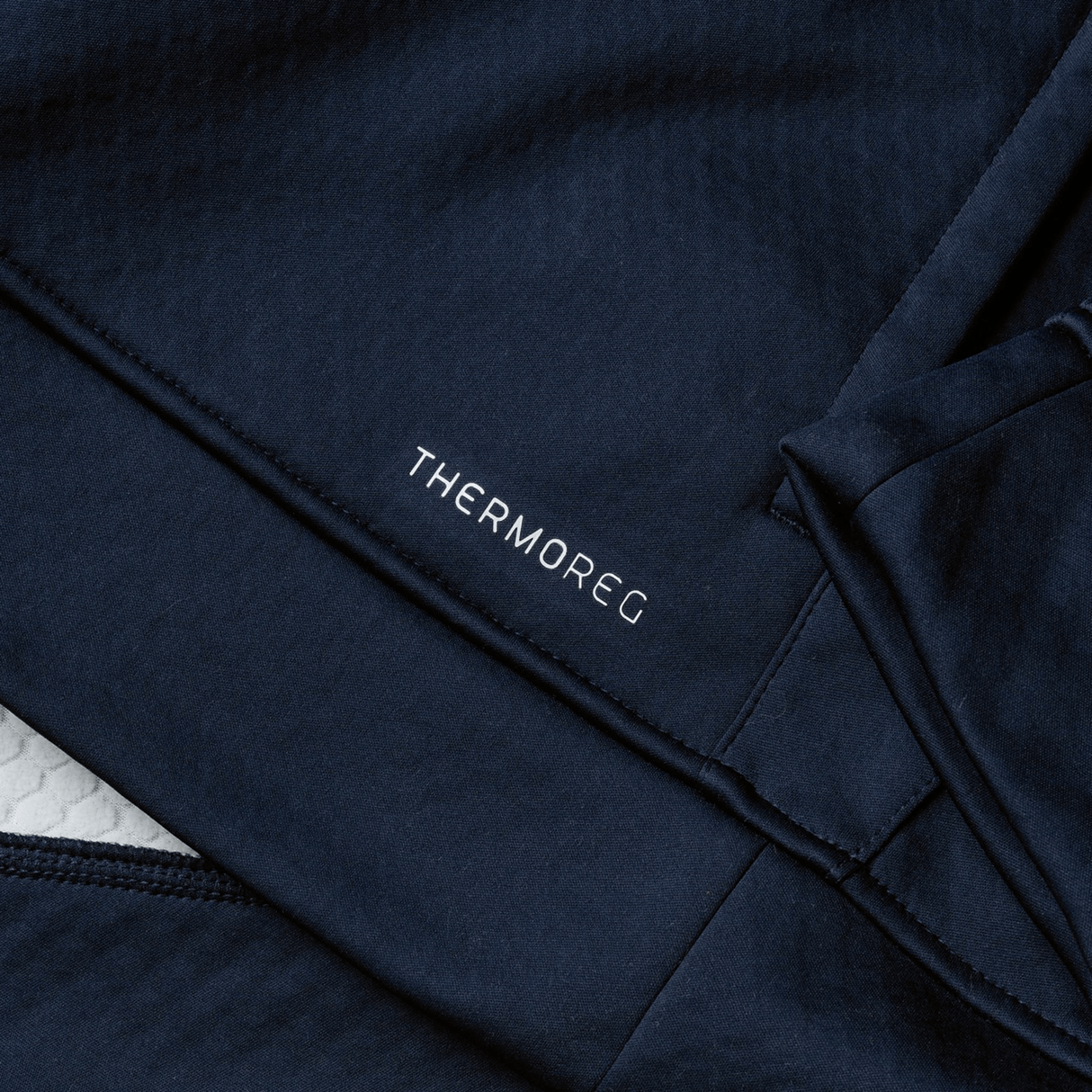 Close-up of dark blue fabric showcasing the word "THERMOREG" in white, echoing Canterbury's high-performance aesthetics, ideal for the British & Irish Lions 2025 1/4 Zip Fleece by Canterbury.