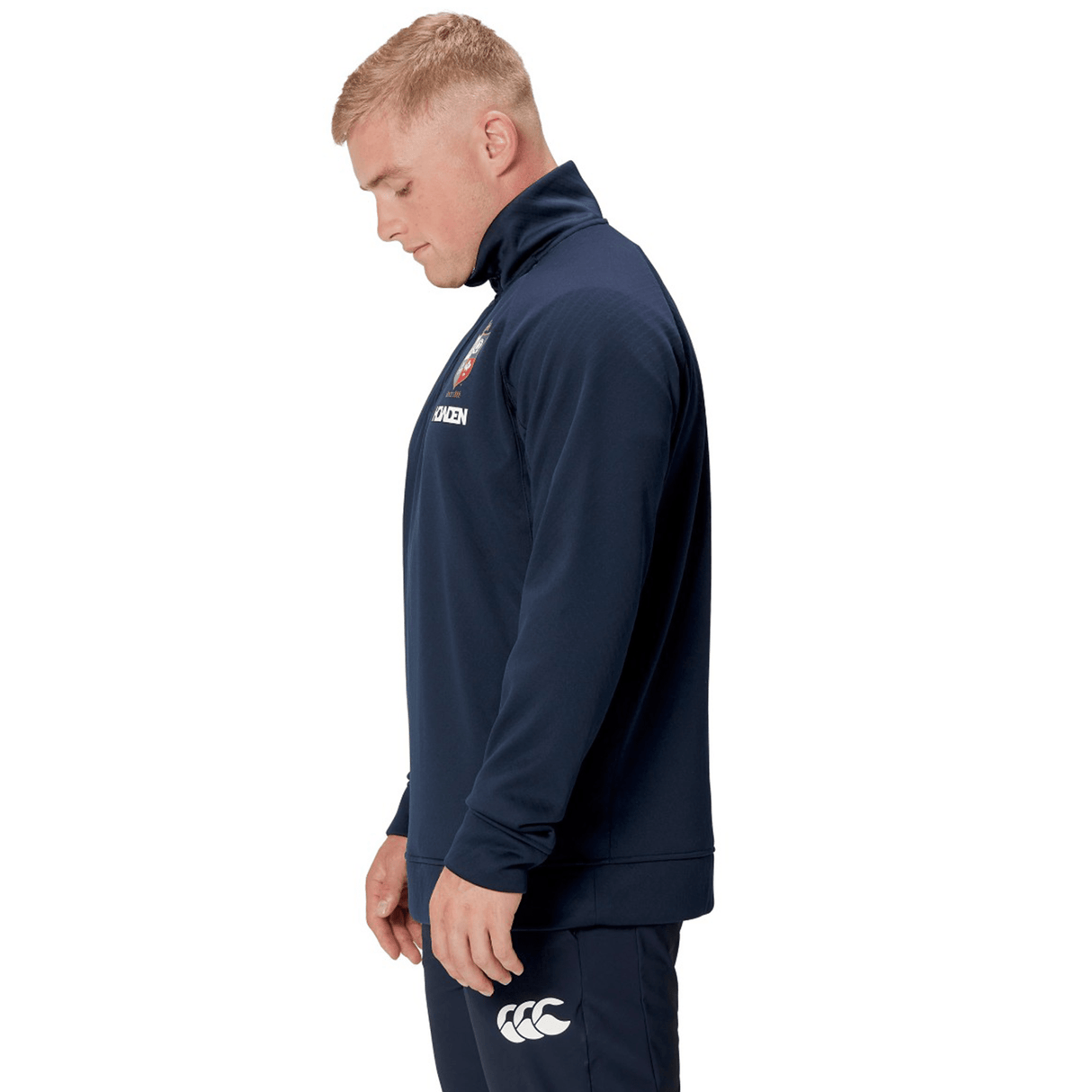 A man wearing a Canterbury British & Irish Lions 2025 1/4 Zip Fleece in navy stands in profile view, proudly displaying his affiliation with the British & Irish Lions.