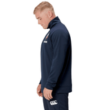 A man wearing a Canterbury British & Irish Lions 2025 1/4 Zip Fleece in navy stands in profile view, proudly displaying his affiliation with the British & Irish Lions.