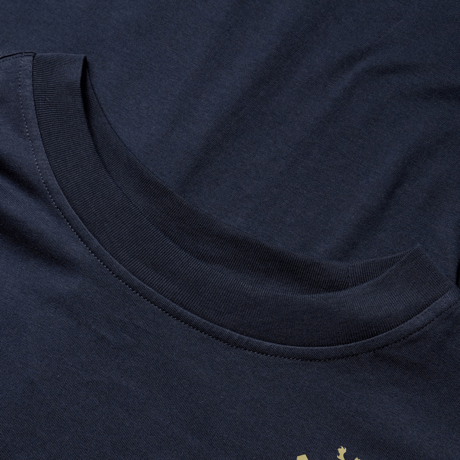 Close-up of the British & Irish Lions 2025 Cotton Jersey Tee by Canterbury, showcasing its dark blue organic cotton fabric with a round neckline that highlights the texture and stitching details.