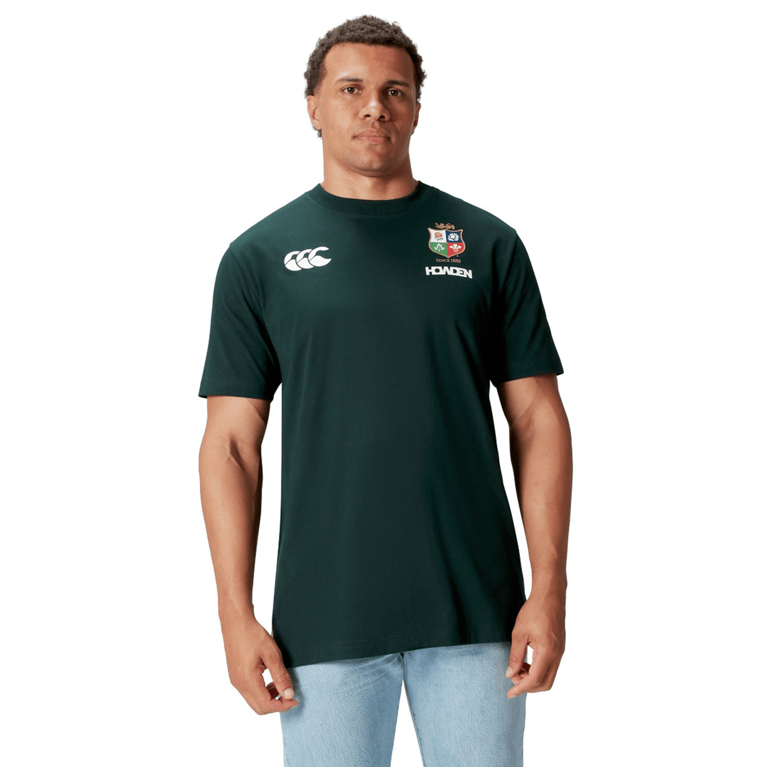 A rugby supporter proudly dons the British & Irish Lions 2025 Cotton Jersey Tee by Canterbury, featuring logos and crafted from organic cotton, set against a crisp white background.