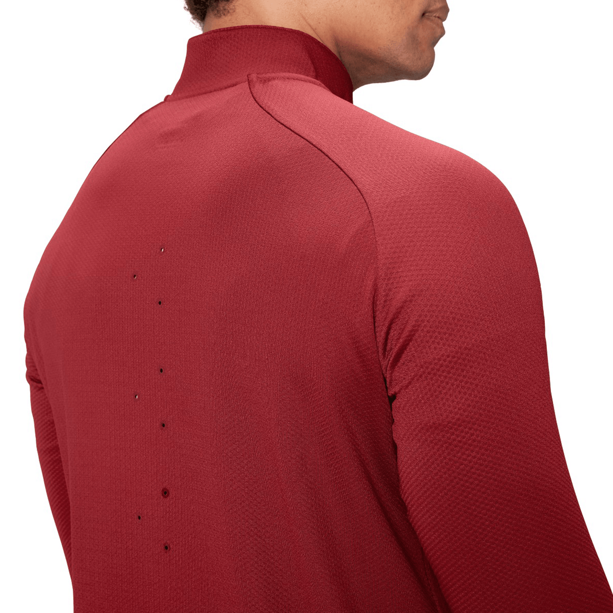 A man wearing a British & Irish Lions 25 Everest First Layer Top by Canterbury in vibrant red, featuring small ventilation holes on the back, faces away from the camera.