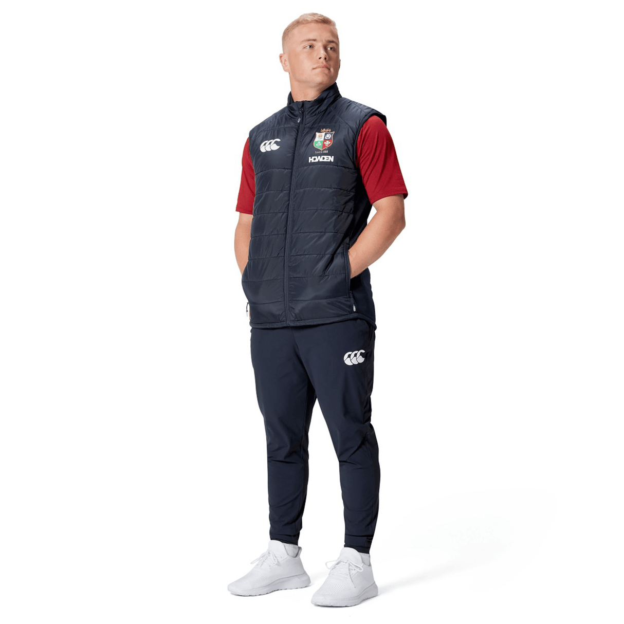 A person wearing the British & Irish Lions 2025 Microlight Gilet by Canterbury, crafted from recycled polyester, stands with hands in pockets against a white background.