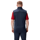 A person with short blonde hair is standing, facing away, wearing a British & Irish Lions 2025 Microlight Gilet by Canterbury made from recycled polyester over a red short-sleeve shirt and navy pants.
