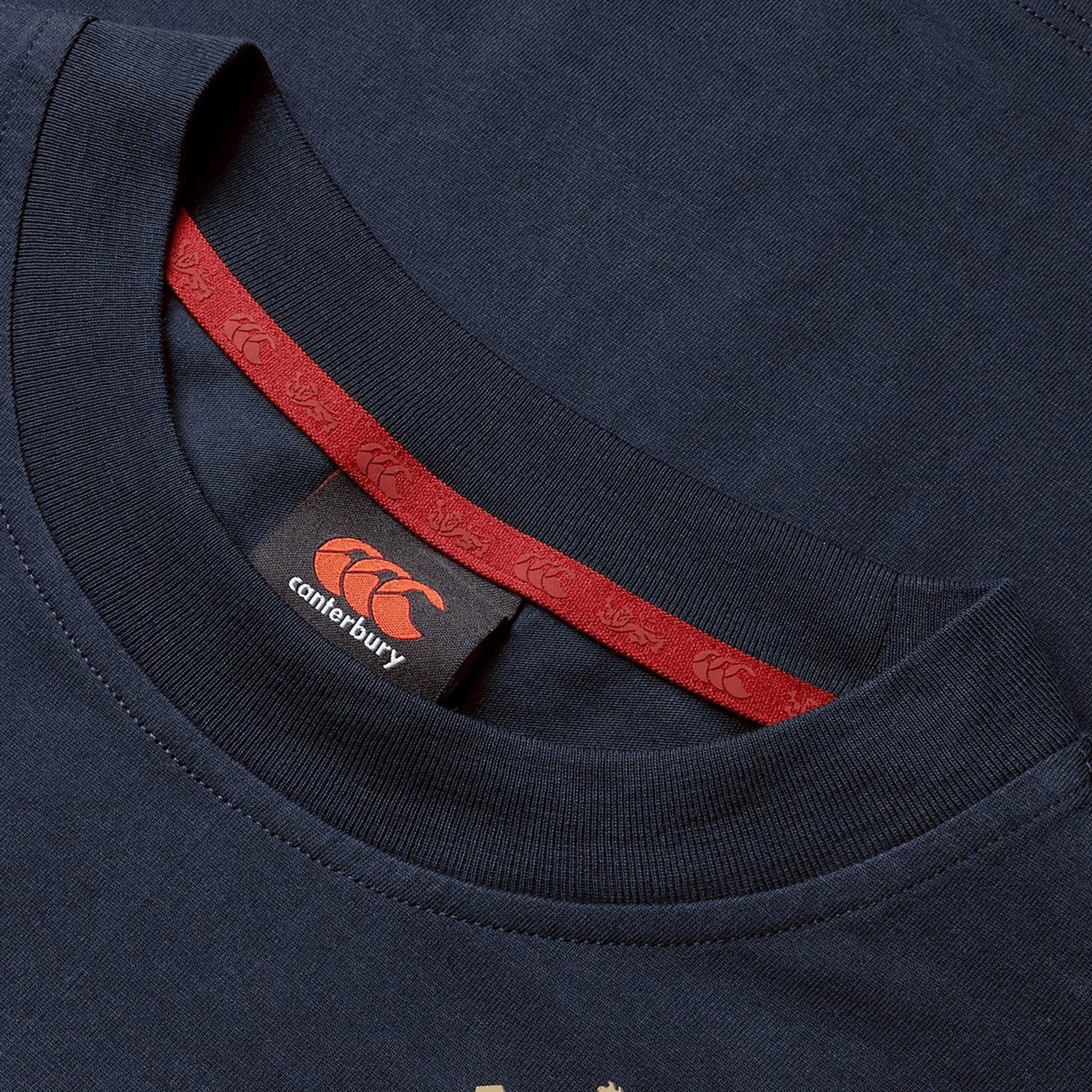 Close-up of the Women's British & Irish Lions 25 Cotton Jersey Tee by Canterbury in navy blue, crafted from organic cotton. It features a striking red neckline detail and a Canterbury logo on the inner label—an essential for any British & Irish Lions rugby supporter.