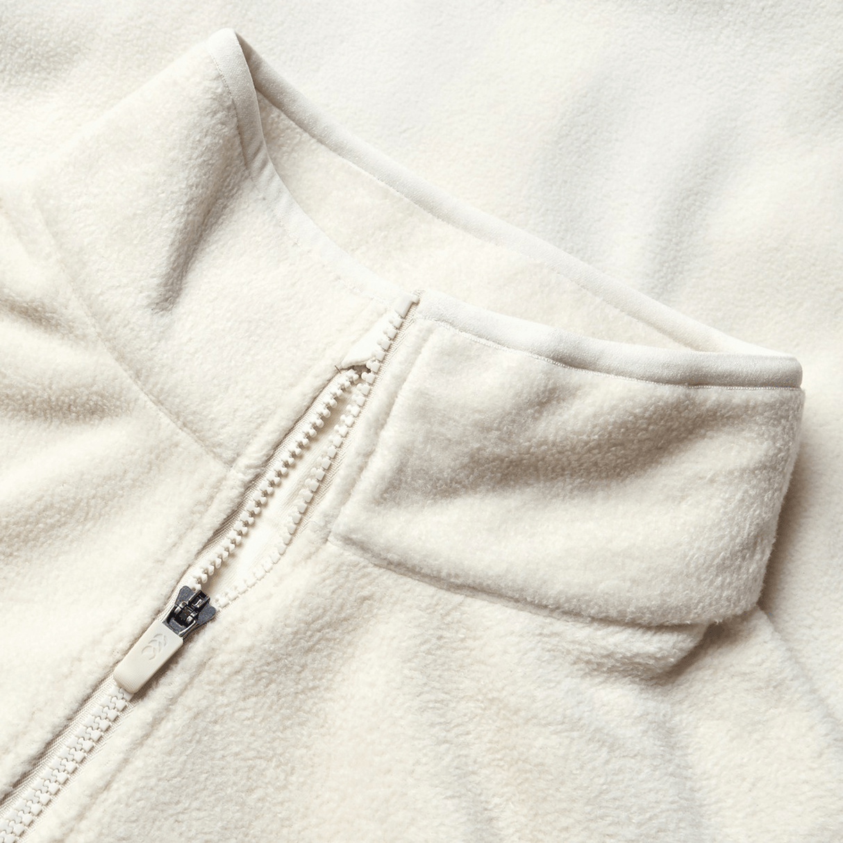 Close-up of the cream-colored British & Irish Lions 2025 Outback Full-Zip Fleece Jacket by Canterbury, showcasing a stand collar and full-zip design, reflecting the classic style celebrated by the British & Irish Lions.
