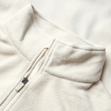 Close-up of the cream-colored British & Irish Lions 2025 Outback Full-Zip Fleece Jacket by Canterbury, showcasing a stand collar and full-zip design, reflecting the classic style celebrated by the British & Irish Lions.